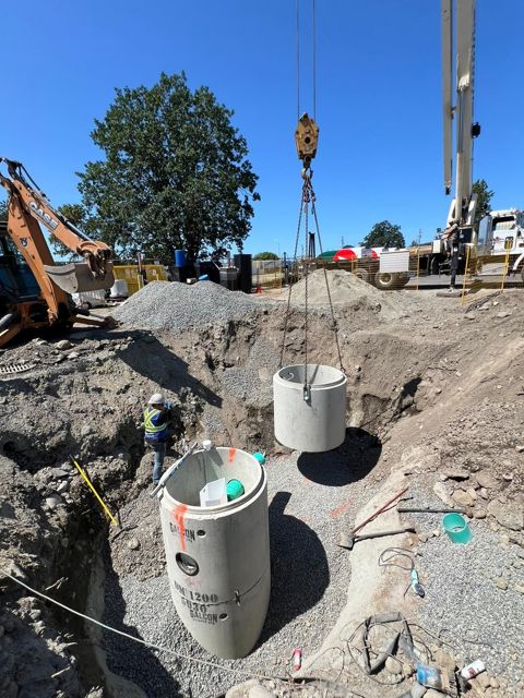 Crane lifting precast riser into place