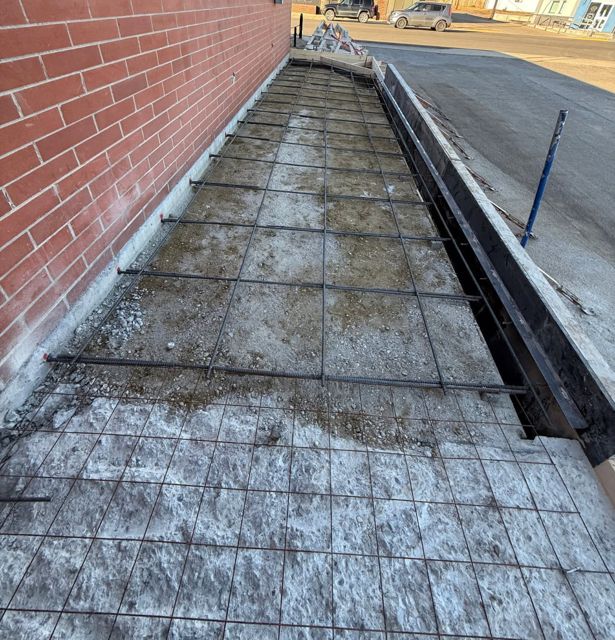 Rebar mat and forms laid out along the building