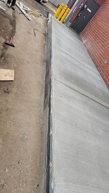 Finished concrete ramp with steel-edged curb